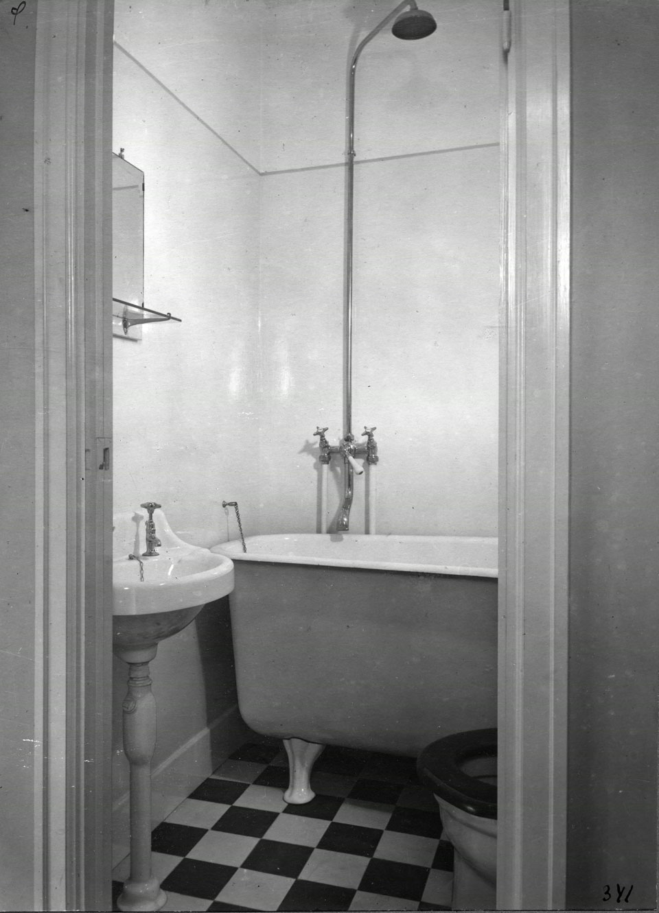 Ett badrum med tvättställ, badkar och toalett från 1930-talet.