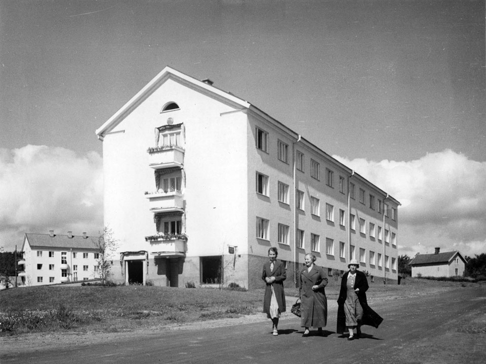 Tre kvinnor som promenerar framför ett HSB-bostadshus i Skara på 30-talet